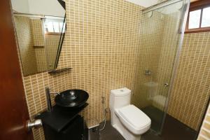 a bathroom with a toilet and a glass shower at Crown hills kandy in Kandy