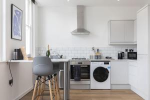 a white kitchen with a dishwasher and a stove at Beautifully presented newly renovated city-centre apartment in Cheltenham in Cheltenham