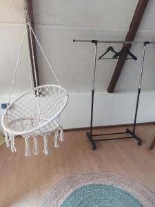 a white swing in a room with a wooden floor at Balabani Local Stay in Podgorica
