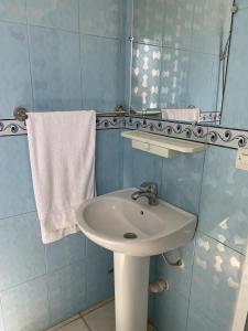 uma casa de banho com lavatório, espelho e toalhas em Hôtel Titrit em Tafraout