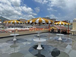 a patio with tables and umbrellas on a roof at Sundeck Suites in Boissiere Village