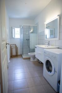 a bathroom with a washing machine and a sink at APPARTEMENT TERRASSE La Citadelle Appartements Saint Florent in Saint-Florent