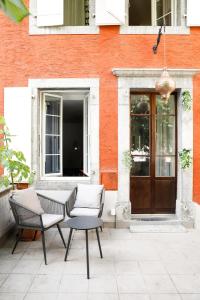 a patio with a table and chairs in front of a building at Marché 28 Guesthouse in Montreux