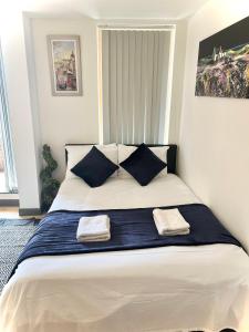 a bedroom with a large bed with two towels on it at White chapel Holiday 2 Bedroom Apartment in London