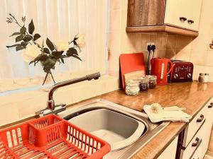 a kitchen sink with a dish drying rack next to it at Spacious 3 Bedroom House - Sleeps 5 in Manchester