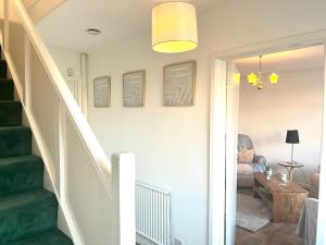 einen Flur mit einer Treppe und ein Wohnzimmer in der Unterkunft Spacious 3 Bedroom House - Sleeps 5 in Manchester