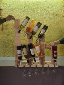 un estante de vinos con botellas de vino y copas de vino en Simurg Evleri Olympos, en Olympos