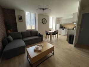 a living room with a couch and a table at T2entièrement rénové style industriel in Rodez