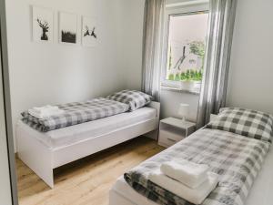 a bedroom with two beds and a window at Domek Moszna in Moszna