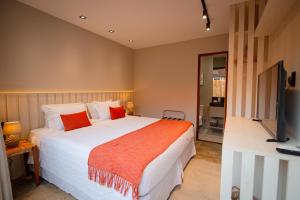费尔南多 - 迪诺罗尼亚Pousada Xica的一间配有大床和平板电视的卧室