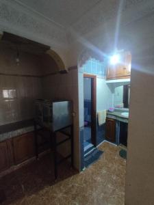 a kitchen with a stove and a microwave in it at Maison en lieu calme in El Jadida