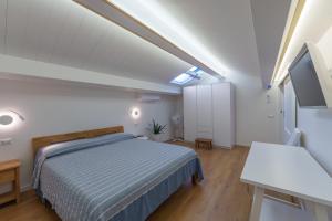 a bedroom with a bed and a tv in it at Appartamento Rena Bianca in Santa Teresa Gallura