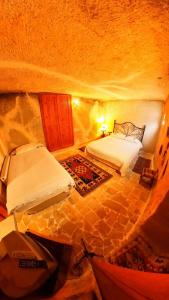 MustafapaşaMonastery cave Hotel Cappadocia的一间洞穴内带两张床的卧室