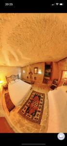 a room with two beds and a rug at Monastery cave Hotel Cappadocia in Mustafapaşa