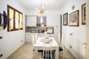 a dining room with a white table and chairs at Zeus in San Giorgio Ionico