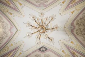 Cette chambre dispose d'un plafond avec un lustre. dans l'établissement Zeus, à San Giorgio Ionico