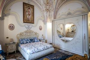 - une chambre avec un lit et un grand miroir dans l'établissement Zeus, à San Giorgio Ionico