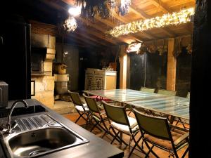 a kitchen with a long table with chairs and a sink at LA SOURCE DE BARDON in Saint-Aignan