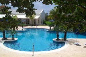 a large pool with palm trees in front of a building at Royal Westmoreland - Royal Apartment 214 by Island Villas in Saint James