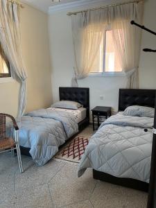 a bedroom with two beds and a window at Hôtel Titrit in Tafraout