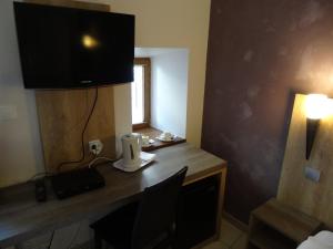 Zimmer mit einem Schreibtisch, einem Laptop und einer Lampe in der Unterkunft La Vieille Tour in Salavas