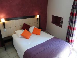 Schlafzimmer mit einem Bett mit orangefarbenen und violetten Kissen in der Unterkunft La Vieille Tour in Salavas