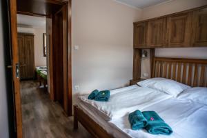1 dormitorio con 1 cama con 2 toallas azules en Bocor Fogadó, en Kisharsány