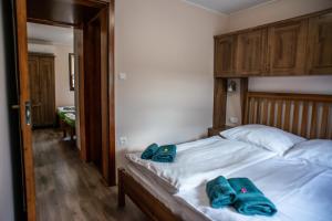 a bedroom with a bed with two blue towels on it at Bocor Fogadó in Kisharsány