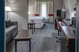 Habitación de hotel con cama y sofá en Four Points Memphis Southwind en Memphis