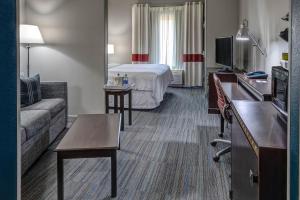 Habitación de hotel con cama y sofá en Four Points Memphis Southwind, en Memphis