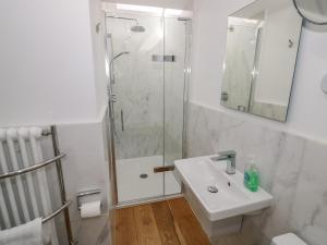 a white bathroom with a shower and a sink at Hillcroft in Kenilworth