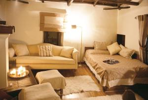 een woonkamer met een bank, een bed en een tafel bij Santikos Mansion in Vizitsa