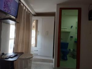 a room with a bathroom with a toilet and a television at Alojamiento San Felipe in Cartagena de Indias