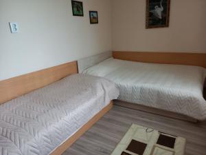 two twin beds in a room with a rug at Вила Боби in Tsigov Chark