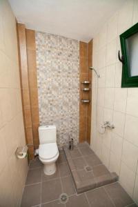 Un pequeño baño con inodoro y ducha. en Infinity Lux, en Agia Paraskevi