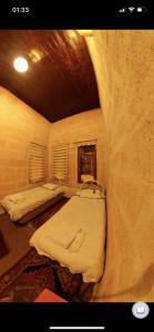 a room with three bunk beds in a cave at Monastery cave Hotel Cappadocia in Mustafapaşa