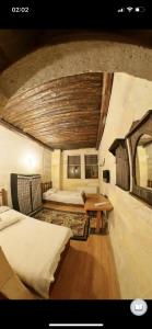 a bedroom with two beds and a table in a room at Monastery cave Hotel Cappadocia in Mustafapaşa