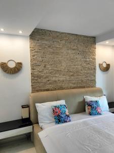 1 dormitorio con cama y pared de ladrillo en City Park Apartment, en Constanţa