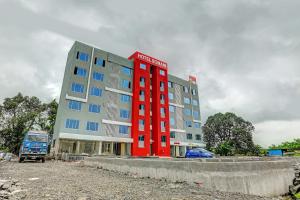 a red building in front of a building at Townhouse 82843 Hotel Somani in Āpta
