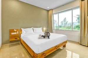 a bedroom with a large bed and a window at Townhouse 82843 Hotel Somani in Āpta