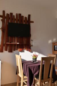 a dining room with a table and a television on a wall at Tropikal Freskia Bunec in Sarandë