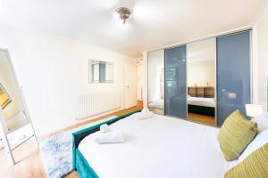 Schlafzimmer mit einem großen weißen Bett und Glaswänden in der Unterkunft The Queensborough Apartments by Hyde Park in London