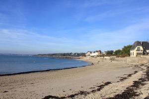 uma praia com pessoas andando na areia e na água em Maison de centre-ville avec grande terrasse em Concarneau