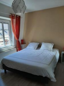 1 dormitorio con 1 cama grande y cortina roja en Maison de centre-ville avec grande terrasse en Concarneau