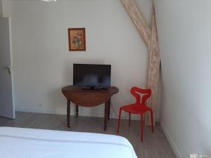 um quarto com uma secretária e uma cadeira vermelha em Maison de centre-ville avec grande terrasse em Concarneau