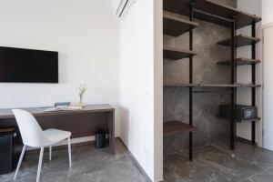 an office with a desk and a tv and shelves at Hotel Mhami in Pulsano