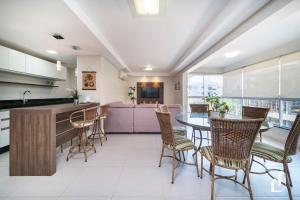 cocina y comedor con mesa y sillas en Kremer Residence - Apartamento 302: Com todos os ambientes climatizados, en Bombinhas