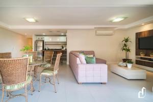 sala de estar con sofá, mesa y sillas en Kremer Residence - Apartamento 302: Com todos os ambientes climatizados, en Bombinhas
