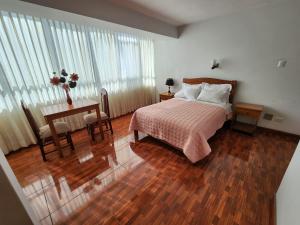 a bedroom with a bed and a table with a table sidx sidx sidx at Hotel Oceano Mit in Tacna