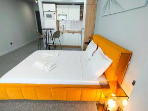 an orange bed in a room with a kitchen at The Palm Studio in Mamaia